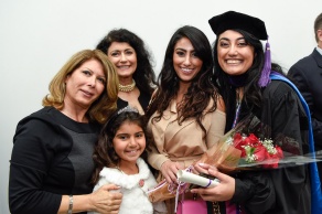 a recent law school graduate posing with her family following commencement. 