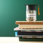 A jar sitting on books with money in it. The jar is labeled "education" with a graduation cap on it. A jar sitting on books with money in it. The jar is labeled "education" with a graduation cap on it. 