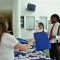 Picture of two new law students at orientation registration table being helped by two current law students. 