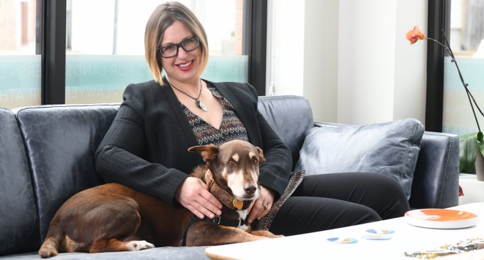 Stephanie Adams with her dog sitting on a sofa. 