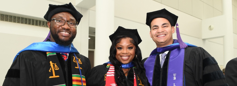 Three students at graduation. 