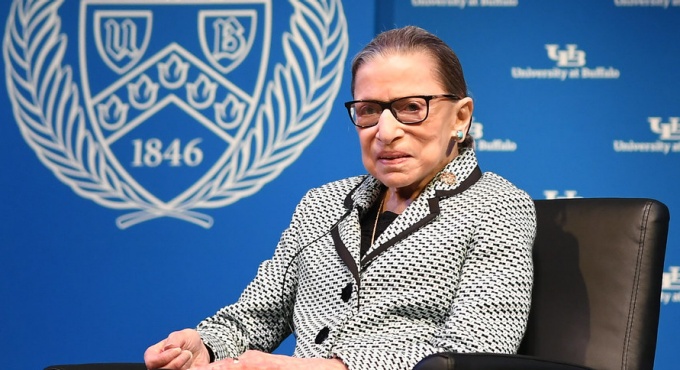 photo of Ginsburg sitting on stage. 