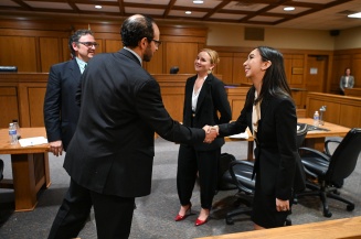 UB Law students shaking hands in the court room. 
