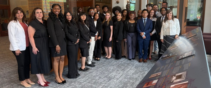 Students and staff participating in a Discover Law program gather for a group photo inside a historic building. 