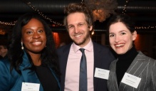 Three people standing together at an event.