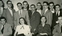Older black and white image of a group of young adults posing together. 