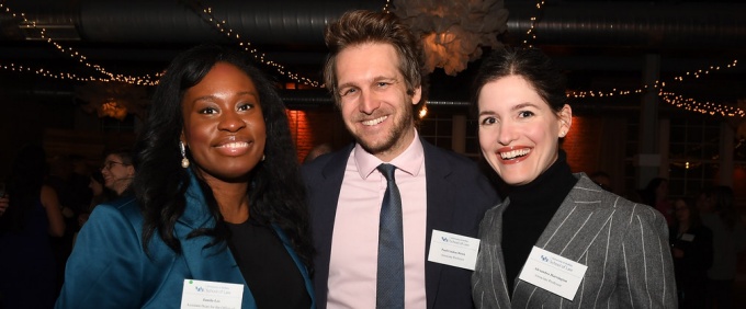 three people standing together smiling. 