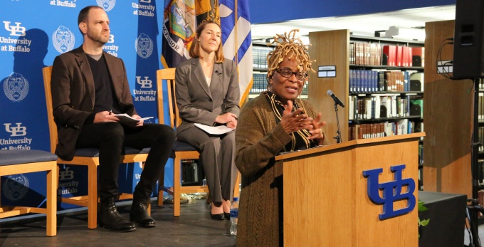 woman talking, standing at a podium. 
