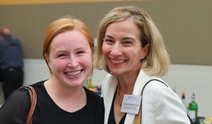 two women posing together, smiling. 