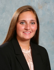 woman wearing black blazer, smiling. 