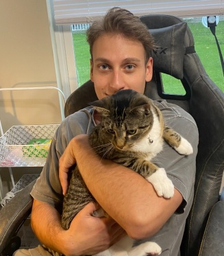 Jon sitting in a chair holding a cat. 