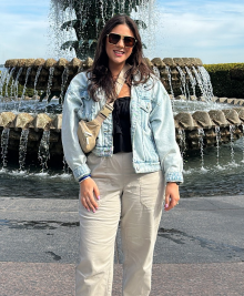 woman standing outside during the day, in front of a decorative fountain. 