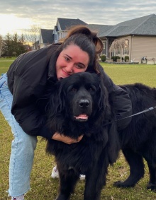 woman outside hugging a dog. 