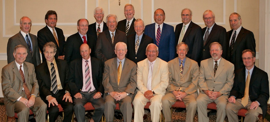 group of alumni inside a large room, posing for their grup photo. 