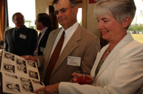 photo of alumni looking at an old student directory. 