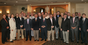 group of alumni standing together, posing for their group photo. 