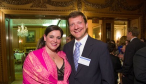 man and woman posing for photo in an ornate room. 