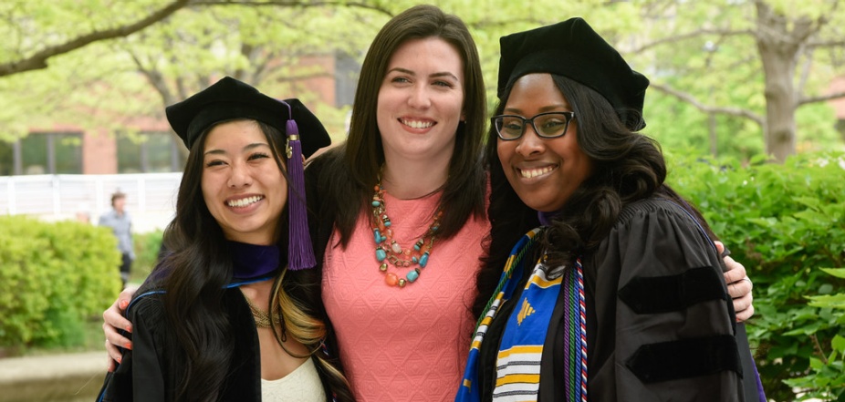 photo of three graduates following their commencement ceremony. 