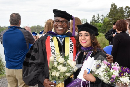 a recent law school graduate posing with her family following commencement. 