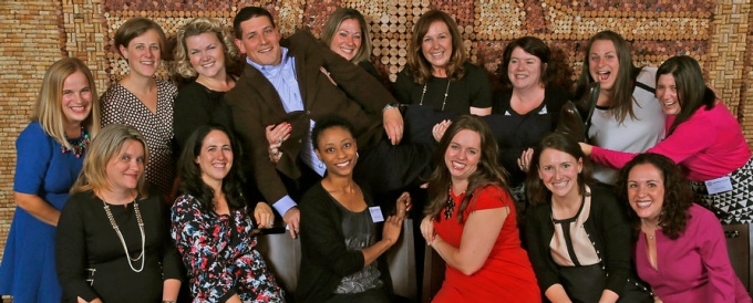 a group photo of people sitting andn smiling. 