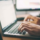 person typing on a laptop computer. 