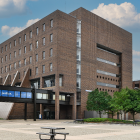 Exterior image of O'Brian Hall, North Campus with the bridge text "Creating opportunity. Fighting for justice". 