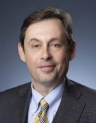 Comerford wearing grey suit, yellow striped tie. 