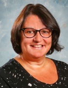 Skopinski wearing black top, glasses, smiling. 