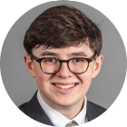 young man wearing glasses, smiling. 