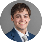 young man wearing a suit and tie, smiling. 