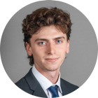 young man wearing a suit and tie, smiling. 