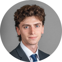 young man wearing a suit and tie, smiling.
