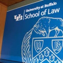 A wall with the UB School of Law logo. 