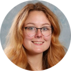 young woman wearing glasses, smiling. 