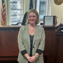 Young woman standing in front of a judges bench. 