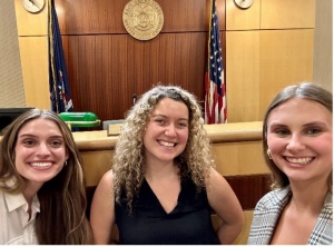 Three young women standing in a courtroom. 