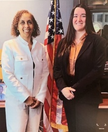 Two adults, lined up for photo with a US flag behind them. 