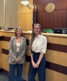 Two young women standing in front of a court bench.