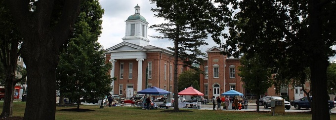 Front view of the Steuben County NY courthouse and county offices in Bath, New York on a sunny day. Photo Credit: J. Passepartout. 