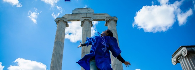 photo of UB undergrad jumping in the air at graduation. 