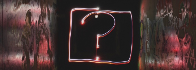 neon red question mark with black background. 