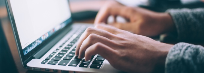 photo of hands typing on a laptop. 