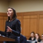 Picture of a law student speaking at a podium in a courtroom. 