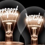 Four light bulbs light up the following words: ethics, respect, honesty, integrity. 