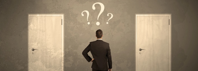 Person in suit looking at two doors with question marks. 