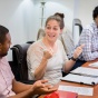 four university at buffalo law students sit at a conference table having a discussion. 