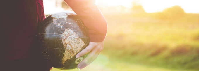 close up photo of person holding a small globe. 