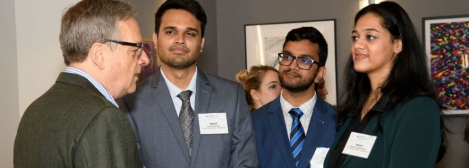 Four people conversing at the NYC Program in Law and Finance reception. 