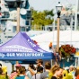 A crowd of people in front of Buffalo's Canalside side with Our City Our Waterfront pop-up tent. 