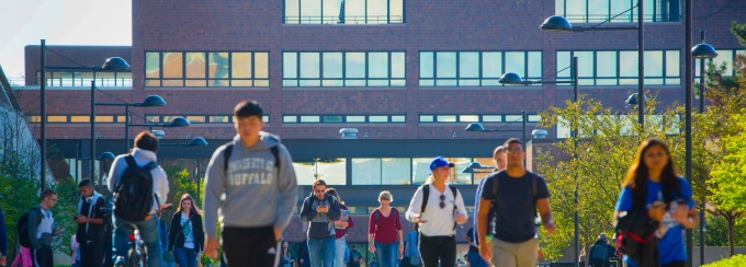 Students walking on the main walkway at the University at Buffalo North Campus with the Capen building in the background. 